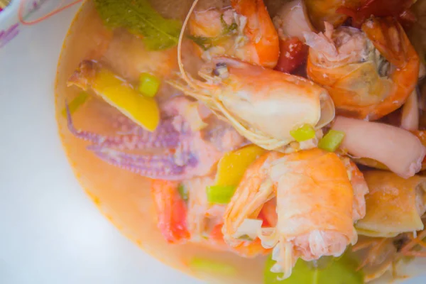 Tom yam kung, or spicy shrimp soup, a classic spicy lemongrass and shrimp soup recipe including squid and other seafood from Thailand. Also known as Tom Yum Goong.
