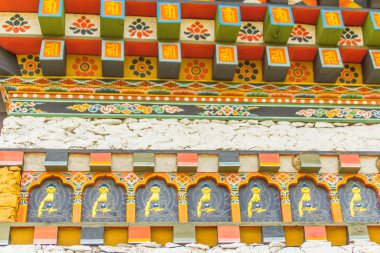 Renkli Bhutan Tapınağı çatı detay. Windows ve kapılar, geleneksel Bhutan mimarisinin güzel süslemeleri.