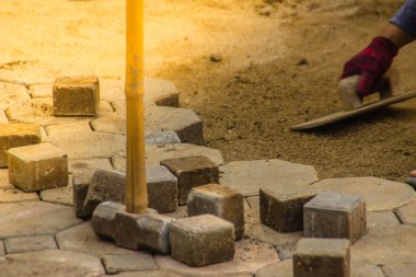 İnşaat işçileri inşaat alanındaki patika iş için beton kaldırım taş döşeme. Kaldırım taşı alt beton kaldırım blok aşağıda bir şehir inşaat sırasında sokak koyuyor.