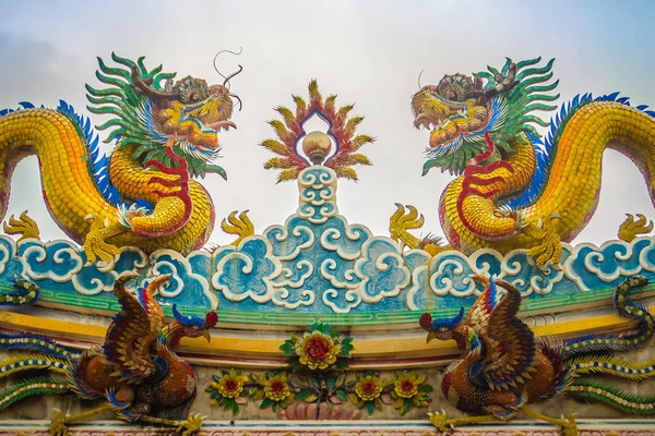美しい大きな顔をしかめる龍中国の寺院で装飾的なタイル屋根の上をクロールします 青い空を背景に竜の像と伝統的な中国の寺院のカラフルな屋根のディテール 選択と集中 — ストック写真