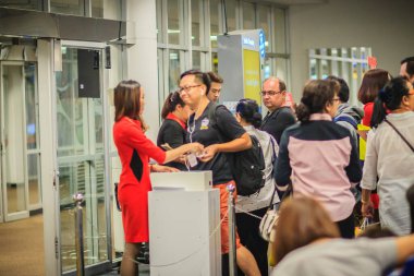 Chiang Mai, Tayland - 3 Mayıs 2017: Uçuş görevlisi Chiang Mai Uluslararası havaalanı terminalinin çıkış kapısındaki yolcuların pasaportlarını ve biniş kartlarını kontrol ediyor.