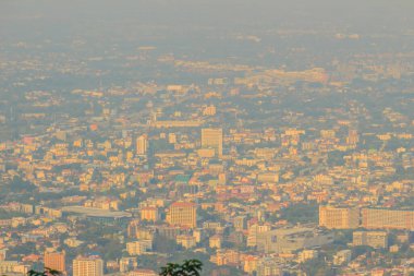 Chiang Mai şehri, duman 2,5 mikrometreden daha az çapa sahip atmosferik partikül maddesi (PM) ile görüş mesafesi kötü olduğunda görülebilir. Chiang Mai, Tayland 'da Kirlilik ve Sis.