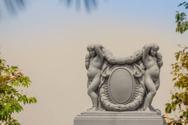 Halk parkındaki çitlerin tepesinde sevimli bir çift Romalı bebek heykeli..