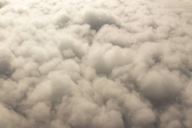 Güzel bulutlar ve gökyüzünden mavi gökyüzü, gökyüzünden ve bulutlardan doğa manzarası. Beyaz bulutlar ve mavi gökyüzü uçak penceresinden cennet gibi görünüyor. Gökyüzündeki güneş ışığı bulutların üzerinde parlar