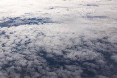 Güzel bulutlar ve gökyüzünden mavi gökyüzü, gökyüzünden ve bulutlardan doğa manzarası. Beyaz bulutlar ve mavi gökyüzü uçak penceresinden cennet gibi görünüyor. Gökyüzündeki güneş ışığı bulutların üzerinde parlar