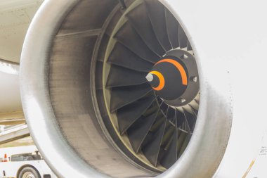Uçak havaalanına park ederken büyük bir jet motoru yaklaşıyor..