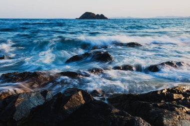Sahildeki kayalar, deniz ve kayalara uzun süre maruz kalma, kayalara vuran dalgalar..