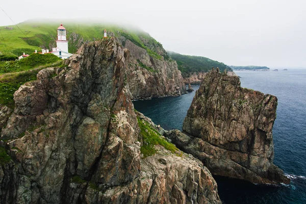 Deniz feneri, okyanustaki büyük kayalar, deniz yazı manzarası, yüksek bir uçurumdaki eski taş bina, Gamova deniz feneri, Rusya, Rusya, Primorsky Krai, Büyük Körfez Peter, Babkin Burnu.