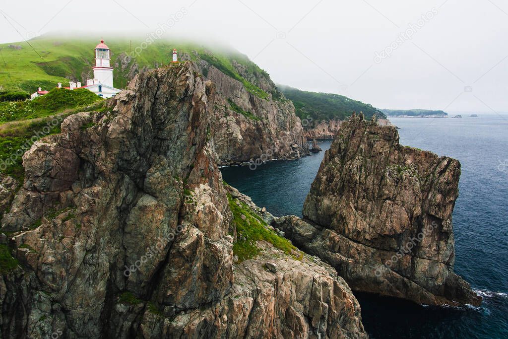 Lighthouse, huge rocks on the ocean, sea summer landscape, old stone building on a high cliff, Gamova lighthouse, Russia, Russia, Primorsky Krai, Peter the Great Bay, Babkin Cape.