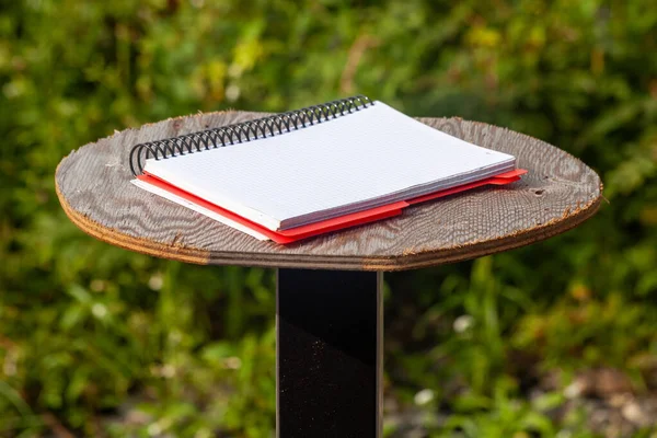 Notepad, an open notebook on a spiral against the background of a summer forest.