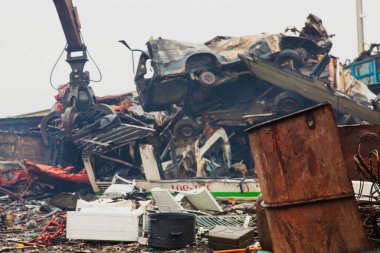 Endüstriyel pençe makinesi, çöp sahasına hurda metal taşı. Kazı kolu, hurda metal tabanlı eski arabalar..