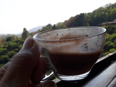 Kakaonun temiz bardaktaki en üst görüntüsü. Tabağı ahşap bir masaya yerleştirilmiş..