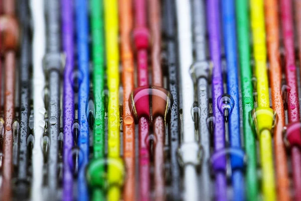 Bright plastic strips of rainbow color with water droplets. Colorful background.Close-up in macro mode.