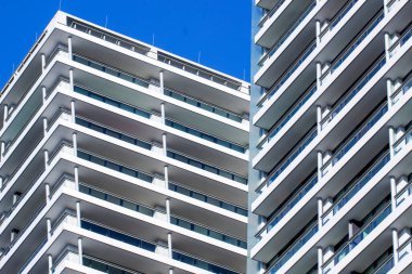 Otelin ön cephesinin bir kısmı mavi gökyüzüne karşı beyaz. Şehir mimarisi minimalizm tarzında..