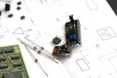 Şematik diyagramın arka planında elektronik parçalar var. Diyotlar, mikroçipler, transistörler, entegre devreler, kapasitörler. Elektronik devre ve elektronik devre tasarımı. Bağlantı diyagramı.