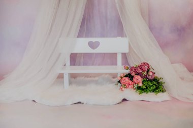 Fotoğraf stüdyosunda pembe çiçekli mini bebek tezgahı.