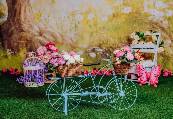Çiçekli mavi bisikletli bir fotoğraf stüdyosunda bahar mini seansı.