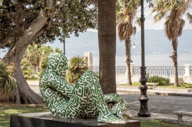 İtalya, Reggio Calabria 'da denize yakın Rabarama heykeli. Bir yaz günü eski Reggio Calabria kasabası. Villa Genoese Zerbi 'yi görmek mümkün.