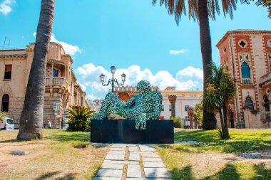 İtalya, Reggio Calabria 'da denize yakın Rabarama heykeli. Bir yaz günü eski Reggio Calabria kasabası. Villa Genoese Zerbi 'yi görmek mümkün.
