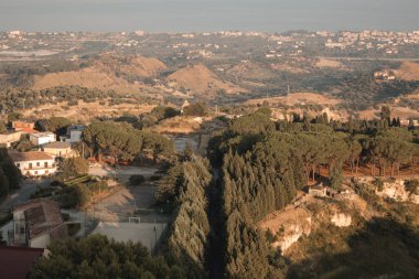 Günbatımında Gerace, Calabria 'nın (İtalya) hava manzarası. Güney İtalya 'da bir köy. Gün batımında Gerace 'in panoramik manzarası, etraflarındaki taş evleri ve odunları görmek mümkün. Köy bir tepede..