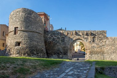 Melfi 'nin ortaçağ şatosunu kapatın. Ortaçağ Güney İtalya şatosu yakın planda ve mavi, berrak bir gökyüzü arka planda. Kale taş tuğlaların içinde ve iki kulesi var..