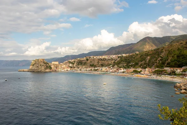 Bulutlu bir günde köylü yolu. İtalya 'nın Calabria şehrinde bir uçurumun kenarında bir İtalyan köyü. Altında deniz ve arkasında bulutlu mavi bir gökyüzü.