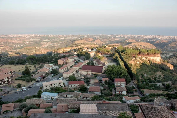 Günbatımında Gerace, Calabria 'nın (İtalya) hava manzarası. Güney İtalya 'da bir köy. Gün batımında Gerace 'in panoramik manzarası, etraflarındaki taş evleri ve odunları görmek mümkün. Köy bir tepede..