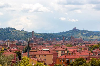 Eski Bologna şehrinin hava panoramik manzarası. Asinelli Kulesi, Torre, San Petronio Kilisesi, Bazilika ve San Luca Kilisesi veya Bazilikası 'nı görmektedir. Bulutlu ve gün batımlı gökyüzü ve arka planda Bolonez tepeleri