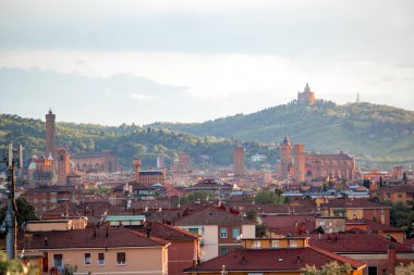 Eski Bologna şehrinin hava panoramik manzarası. Asinelli Kulesi, Torre, San Petronio Kilisesi, Bazilika ve San Luca Kilisesi veya Bazilikası 'nı görmektedir. Bulutlu ve gün batımlı gökyüzü ve arka planda Bolonez tepeleri