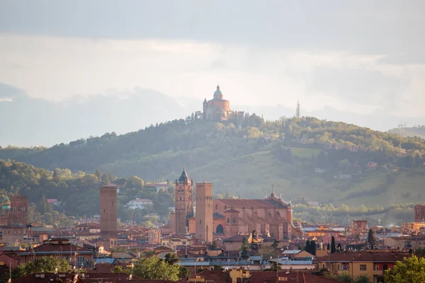Eski Bologna şehrinin hava panoramik manzarası. Asinelli Kulesi, Torre, San Petronio Kilisesi, Bazilika ve San Luca Kilisesi veya Bazilikası 'nı görmektedir. Bulutlu ve gün batımlı gökyüzü ve arka planda Bolonez tepeleri
