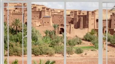 Kuşlar uçarken Ait Ben Haddou şehri beyaz bir pencereden görüldüğü gibi. Kasbah, Fas 'ın Atlas Dağları' nda Ouarzazate yakınlarında görülmektedir. 1987 'den beri UNESCO' nun Dünya Mirası Bölgesi. Kızıl köy.
