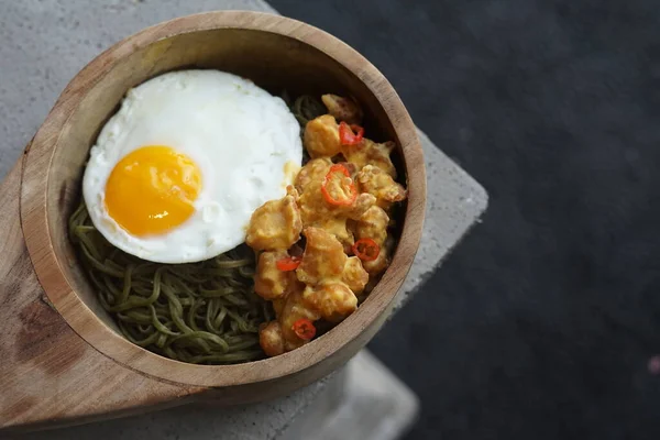 Healthy Green Noodle in a Wooden Bowl with Sunny Side Up and Salted Egg Chicken