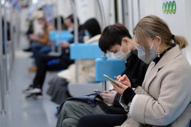 Koronavirüsü önlemek için ameliyat maskesi takan insanlar Şangay 'da metroda oturuyorlar.