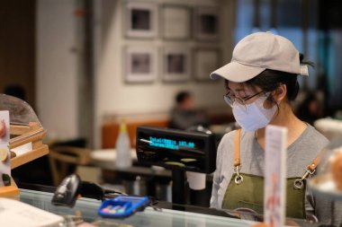 Şangay / Çin-Nisan 2020: Coronavirus COVID-19 Çin 'de kontrol edilmektedir. Cerrahi maske takan kafe çalışanları normal çalışıyor.