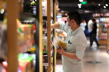 Şangay / Çin-Mayıs 2020: Covid-19 Coronavirus 'u önlemek için maske takan süpermarket memuru