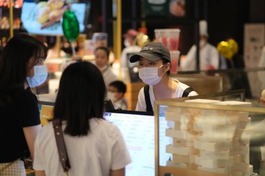 Şangay / Çin-Mayıs 2020: Meyve suyu dükkanında çalışan, müşterilerle konuşan, covid-19 Coronavirus 'u önlemek için yüz maskesi takan katip