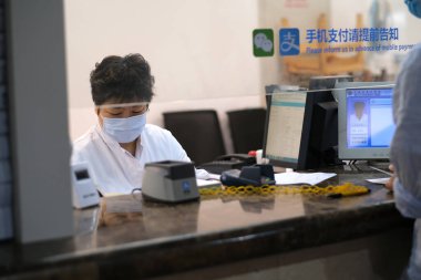 Şangay / Çin-Mayıs 2020: Çalışan bir doktor içeride oturuyor ve Cvid-19 Coronavirus 'u önlemek için maske takıyor.