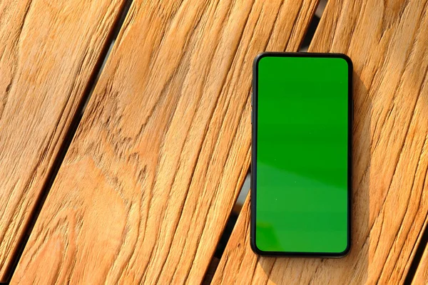Вид Сверху Зеленый Экран Телефона Ретро Деревянный Стол Солнцем — стоковое фото