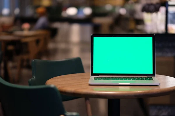 Een Groene Scherm Laptop Computer Houten Tafel Cafe Wazige Achtergrond — Stockfoto