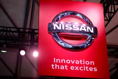 Kırmızı panoda Nissan Şirketi 'nin parlak gümüş renkli logosu var. Heyecan verici bir sloganla. Ünlü Japon çokuluslu otomobil üreticisi. CES ASIA 'ya ateş et