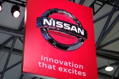 Kırmızı panoda Nissan Şirketi 'nin parlak gümüş renkli logosu var. Heyecan verici bir sloganla. Ünlü Japon çokuluslu otomobil üreticisi. CES ASIA 'ya ateş et