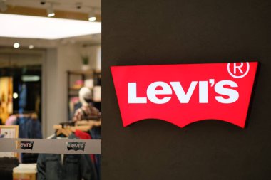 Şangay / Çin-Ekim 2019: Mağazanın dış duvarındaki parlak LEVI logosunu kapatın. Arka plan olarak bulanık giyim mağazası. Bir Amerikan kot markası. 