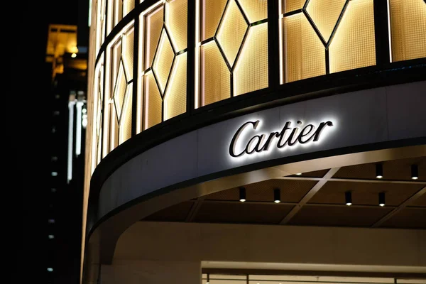 Şangay / Çin-2019: geceleri Cartier 'in parlak dükkan tabelasını kapatın. Bulanık şehir ışıkları. Ünlü Fransız saati ve mücevher üreticisi.