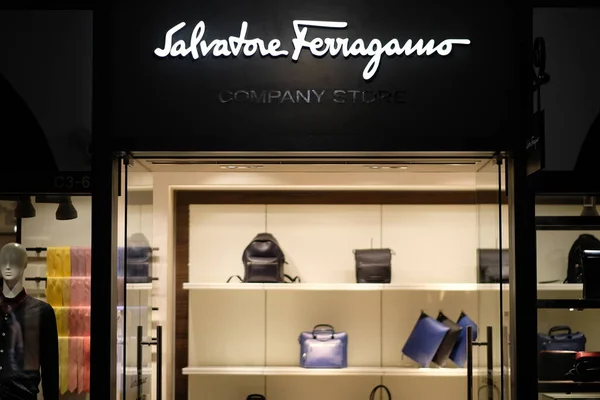 Şangay / Çin-Ekim 2019: Florentia Village Outlets 'teki Salvatore Ferragamo şirketinin ön cephesi. Beyaz markalı logo. İçerideki aydınlanmış giyim mağazası. Bir İtalyan lüks malları şirketi.