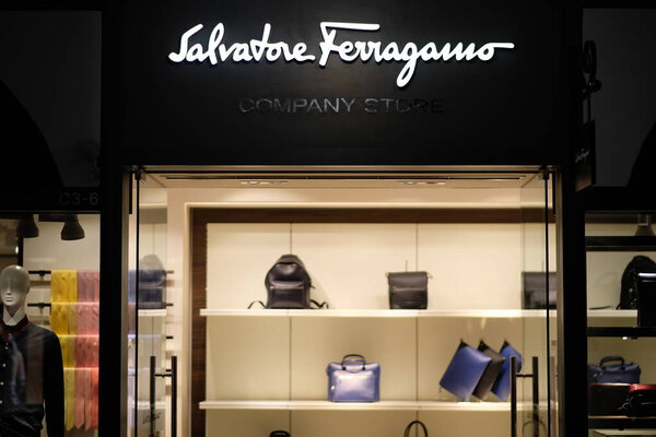 Shanghai/China-Oct.2019: facade of Salvatore Ferragamo company store in Florentia Village Outlets. White brand logo.Illuminated clothing store inside. An Italian luxury goods company
