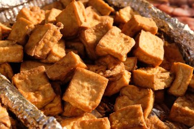 Gün ışığı altında bir sürü kokuşmuş tofu (kokuşmuş tofu) yığınını kapatın. Güçlü bir kokusu olan mayalanmış tofunun bir formu. Geleneksel Çin yemeği