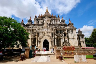 Bagan / Myanmar-Sep.2019: Güneşli mavi gökyüzü bulutları altında Thatbyinnyu Tapınağı cephesi. Bagan 'daki en yüksek pahto. Yerel halk ve turistler girip çıkıyorlar.