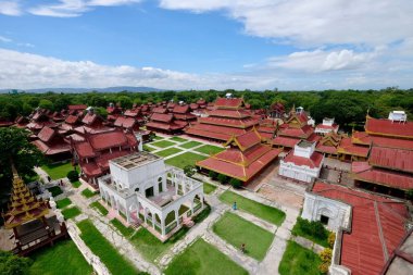 Mandalay / Myanmar-Eylül 2019: Mandalay Kraliyet Sarayı 'nın yüksek açılı manzarası. Kırmızı ve altın renkli retro binalar ve güneşli mavi gökyüzünün altındaki çimenler beyaz bulutlar. Geniş açı