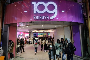 Tokyo / Japonya-Aralık 2019: Geceleri SHIBUYA 109 'un girişi. Müşteriler girip çıkıyorlar. Shibuya 'da ünlü bir mağaza.