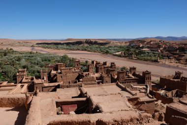 Kahverengi Ait Benhaddou ve güneşli mavi ufuk çizgisi yüksek açılı. Ouarzazate yakınlarındaki Fas 'ta antik berber kasbah. Ait Benhaddou, tahkim edilmiş bir şehir veya saray kralıdır. geniş açı
